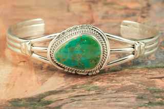 Genuine Royston Turquoise set in Sterling Silver Bracelet. The Royston Turquoise Mine was originally known as the Royal Blue Mine. It produces Turquoise that has a mixture of blues and greens in the same formation. The Royston Turquoise Mine is located in Nye County, Nevada. Created by Navajo Artist Arkie Nelson. Signed by the artist.
